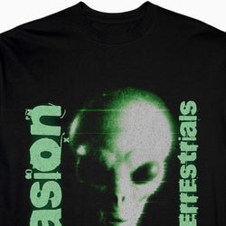 Black t-shirt with green alien graphic and text on a white background