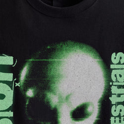 Black t-shirt with green alien design and text on a dark background