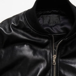 Close-up of a black leather jacket with a zipper on a white background