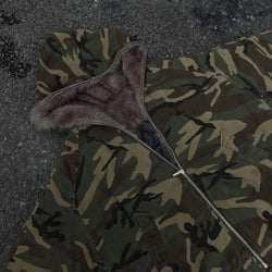 Camouflage jacket with fur-lined hood on a dark surface