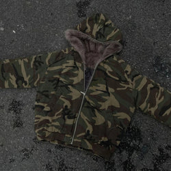 Camouflage jacket with fur-lined hood on a dark textured surface