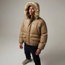 Man wearing a beige puffer jacket with a fur-lined hood on a plain background