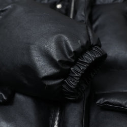 Close-up of a black leather jacket with a focus on texture and stitching.