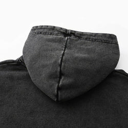 Close-up of a black hooded garment with a white background