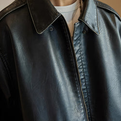 Close-up of a black leather jacket with a zipper
