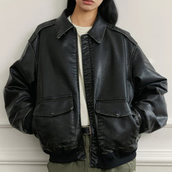 Person wearing a black leather jacket against a neutral background