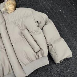 Beige puffer jacket on a black surface