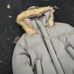Gray puffer coat with fur hood on a dark asphalt surface