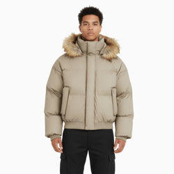 Man wearing a beige puffer jacket with fur hood on a white background