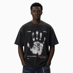 Person wearing a black t-shirt with a handprint design on a plain background